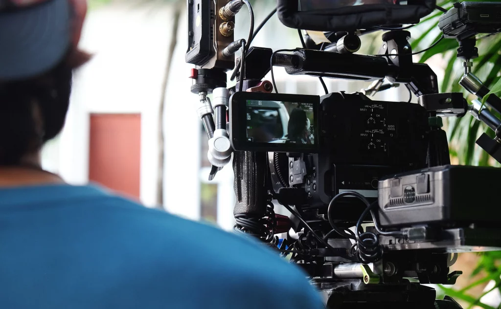 A man using a camera to film a video, highlighting cinematic production services.