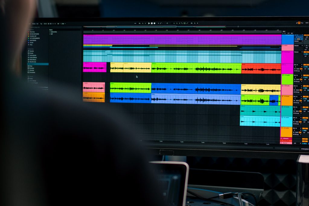 A person using music production software on a computer, focused on audio engineering for podcasts.