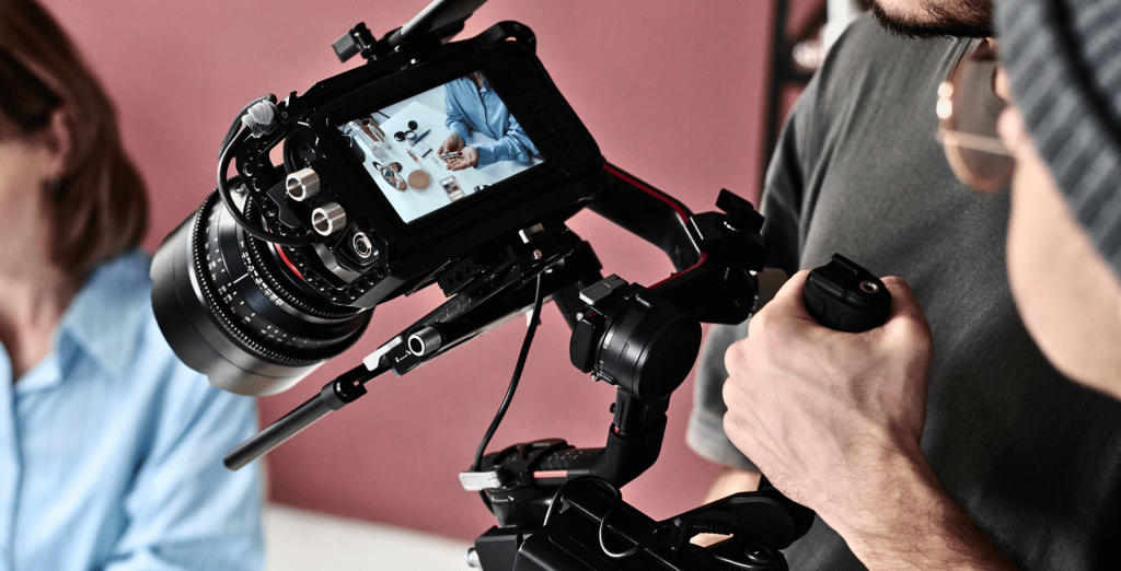 A professional videographer uses a camera rig to film a scene, showcasing the in-process video creation services