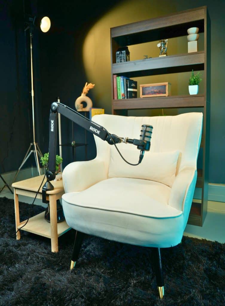 A premium guest recording area at NextMedia London featuring a white armchair and curated studio library.